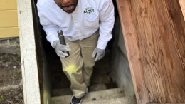 Licensed, pest control expert doing an initial inspection in the basement of Bay Area home